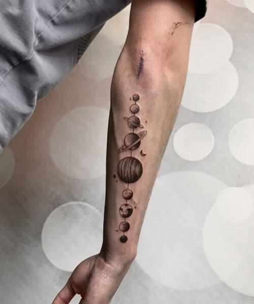 męski tatuaż na przedramieniu planety